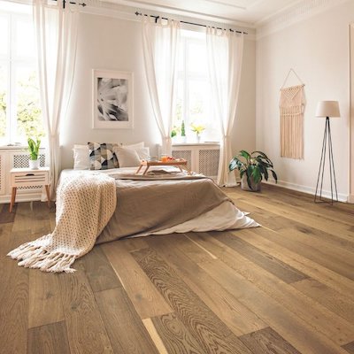 hardwood flooring in a bright neutral bedroom with large windows